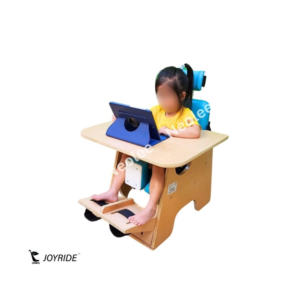 Child with cerebral palsy using the JOYRIDE CP child chair frame with removable activity table and postural support for learning and daily activities.