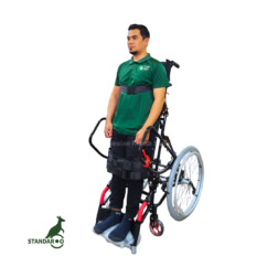 A user standing upright with assistance from the Standaroo standing wheelchair, demonstrating supported standing mobility and rehabilitation support.